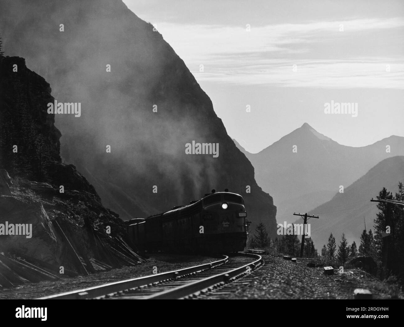 British Columbia, Canada:  November, 1952 A Canadian Pacific diesel freight train at dusk as it passes by Mt. Stephen in the Van Horne Range in the Canadian Rockies. Stock Photo