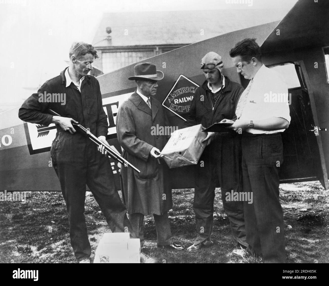 United States:   c. 1928 Workers with rifles and clipboards loading packages for secure shipment on a National Air Transport plane for delivery under the Air Express Division of the American Railway Express Company. National Air Transport was a forerunner of United Air Lines. Stock Photo