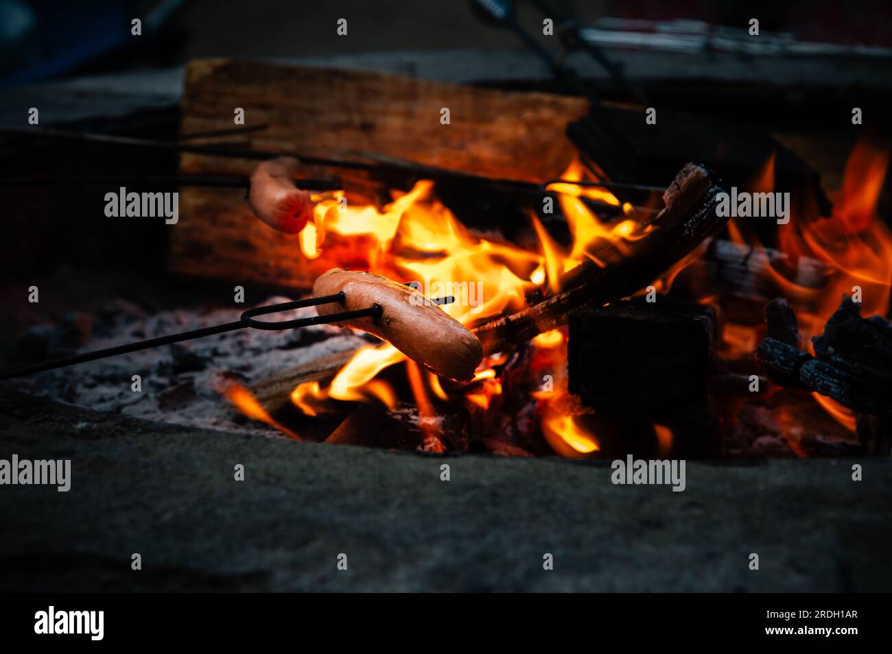 Hotdog roasting over a camp fire Stock Photo