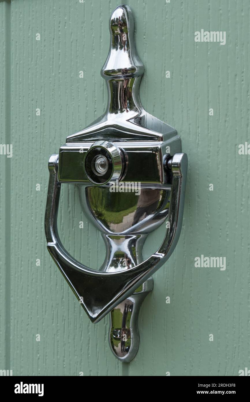 Closeup of ornate silver / chrome finish front door knocker with spy hole / peep hole viewer Stock Photo