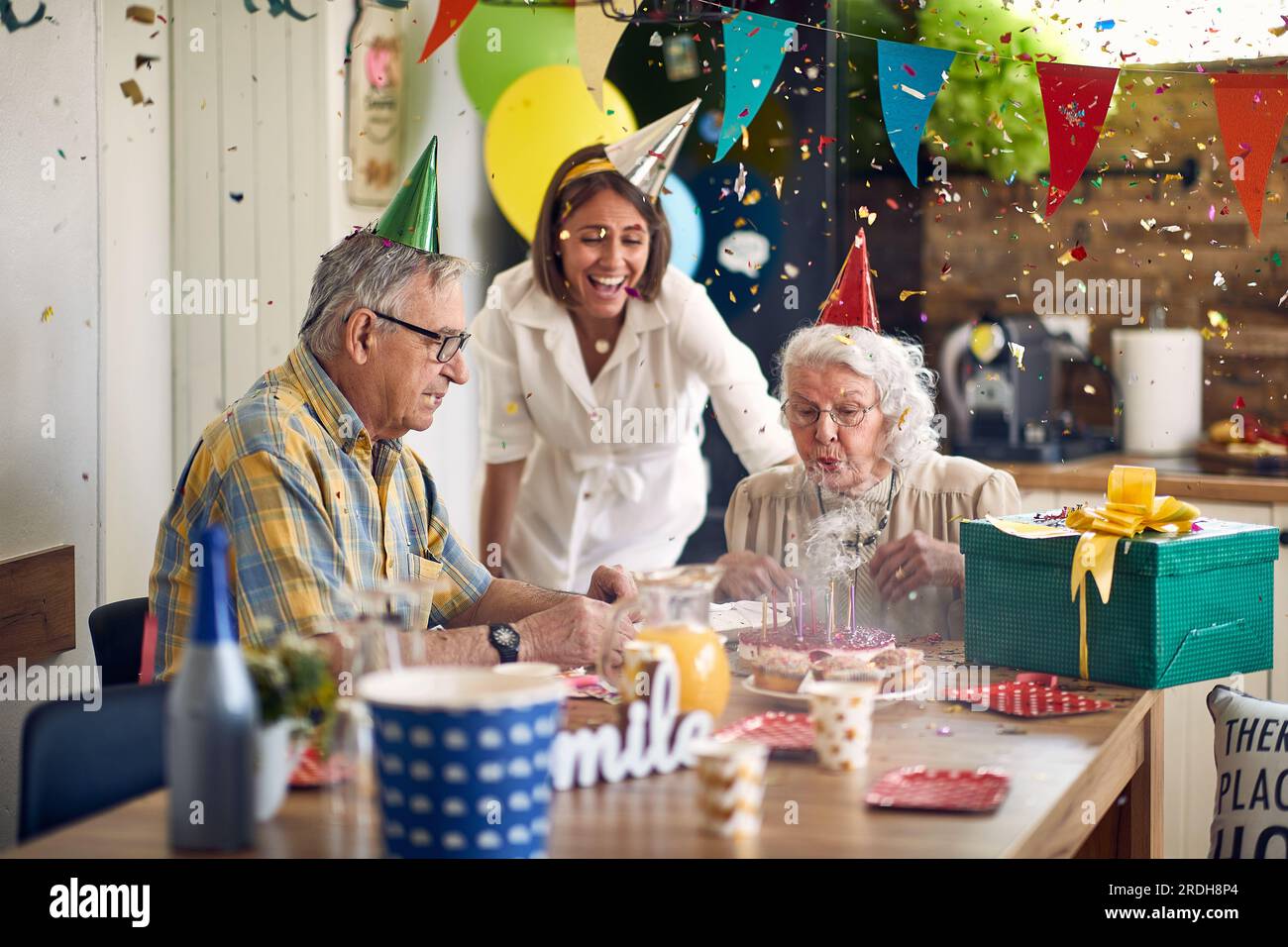 Birthday celebration,grandma blow out the candles on her birthday cake.Surrounding her are not