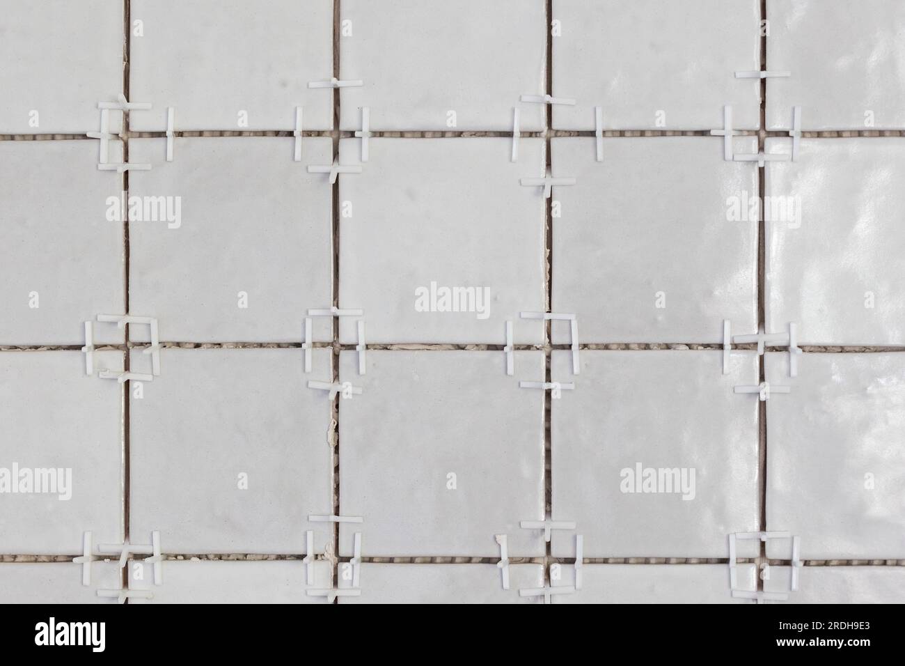 A front portrait of a tile wall under construction. The wall is being