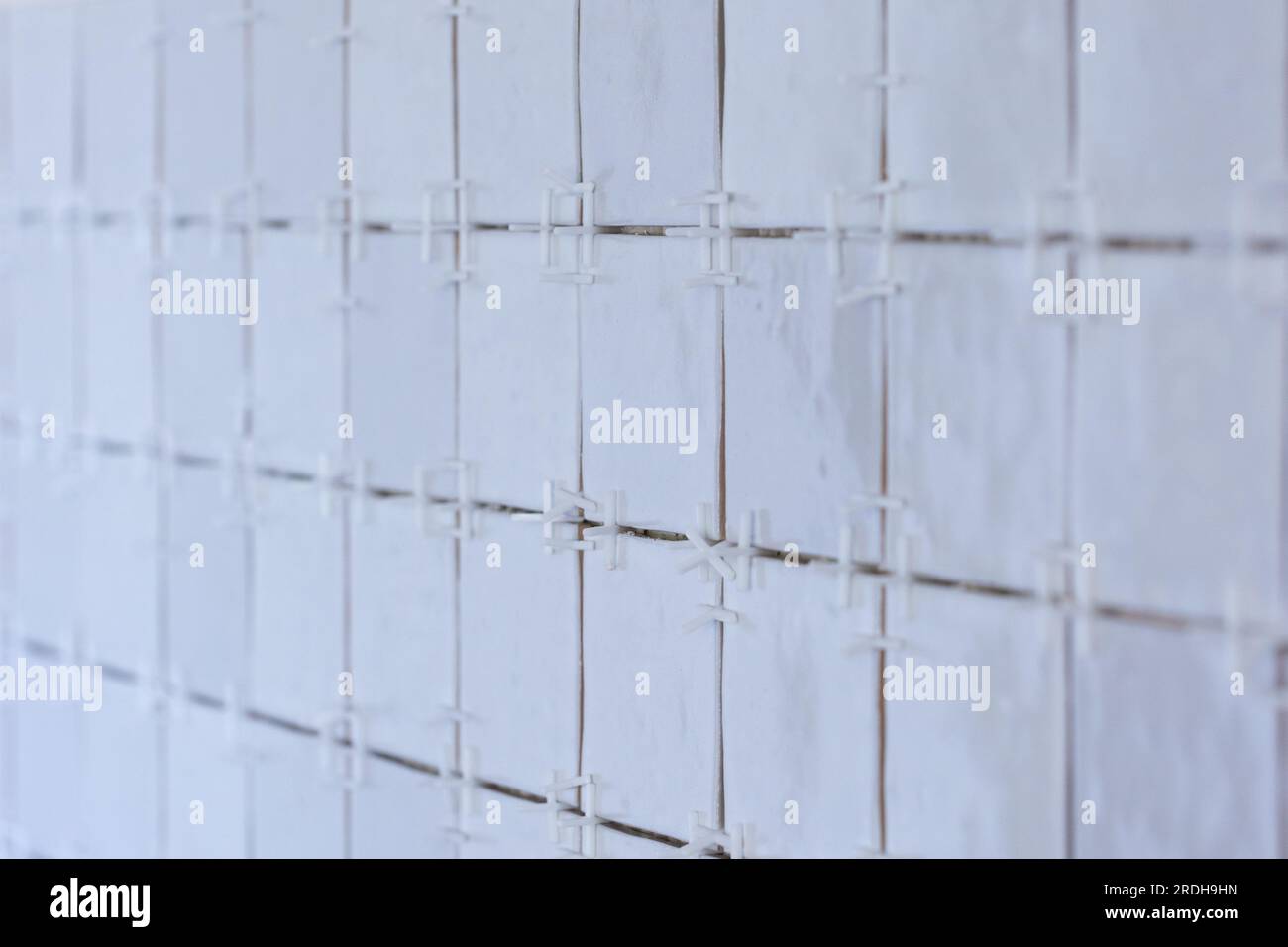A portrait of a ceramic tile wall under construction. The wall is being
