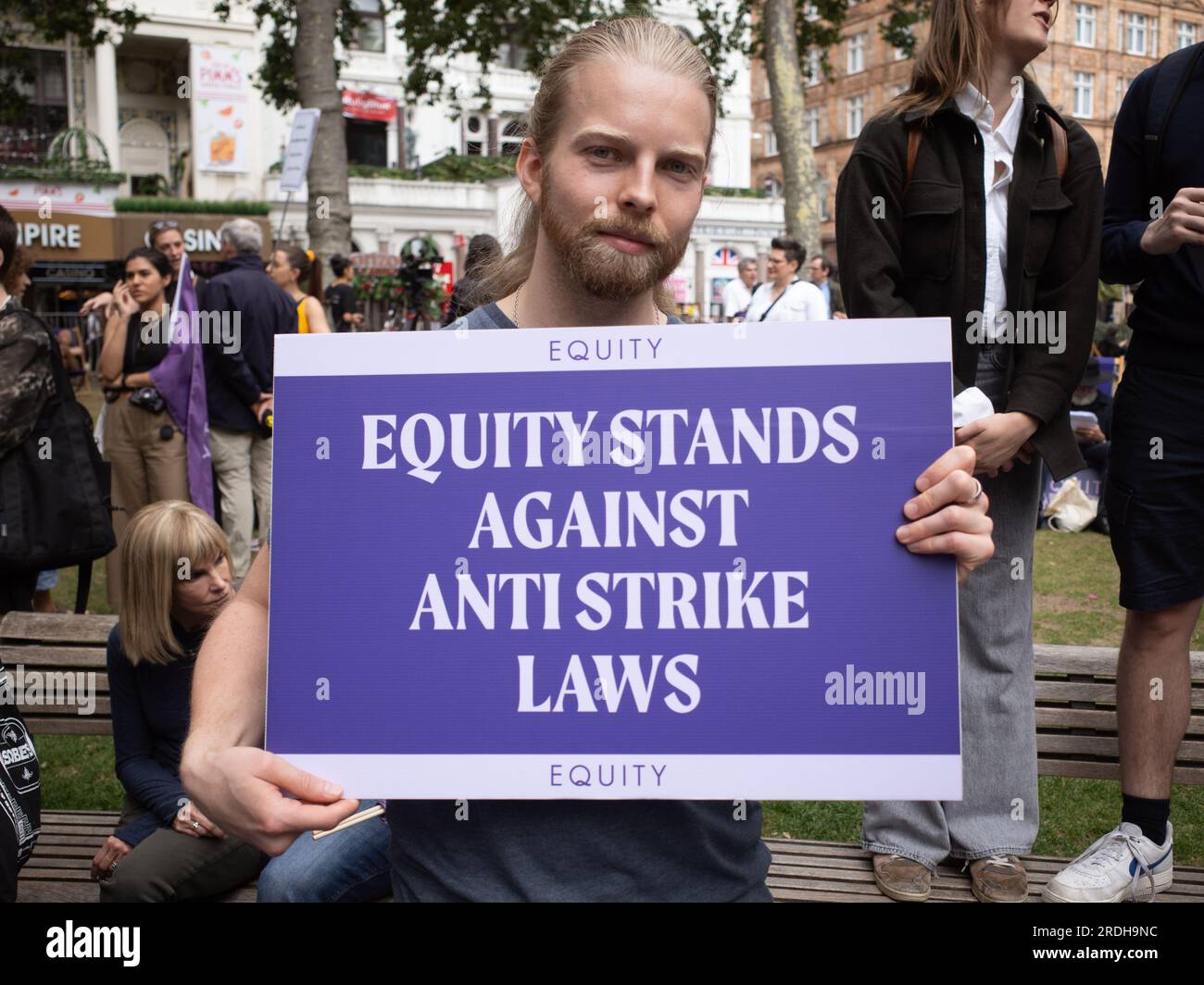 Portrait shot of protester holding Equity trade union banner at the SAG-AFTRA actors strike demonstration in Leicester Square, London, UK. July 2023. Stock Photo