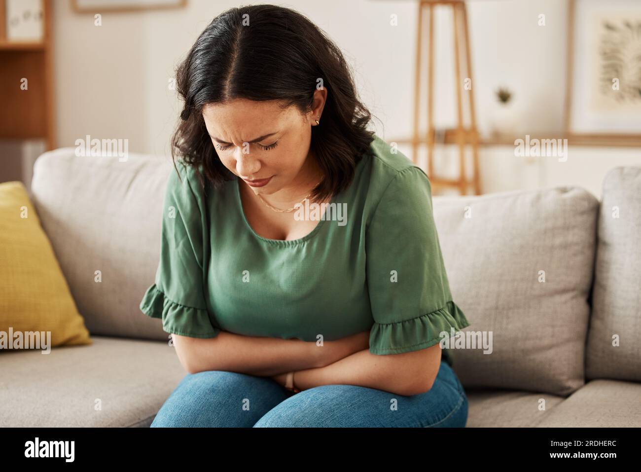 Stress, stomach pain and woman on a sofa with menstruation, gas or