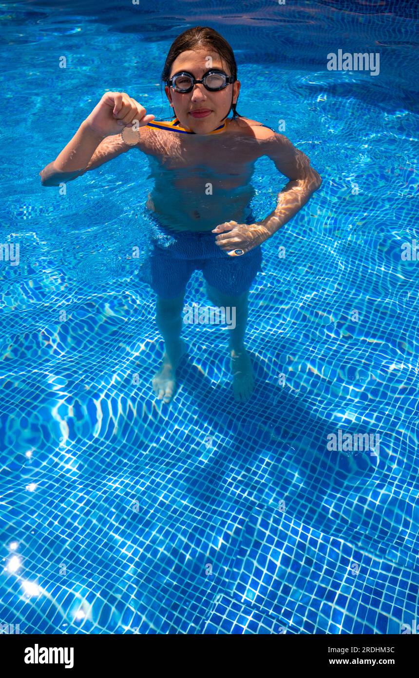 Successful caucasian young swimmer with award in outdoor pool. Golden ...