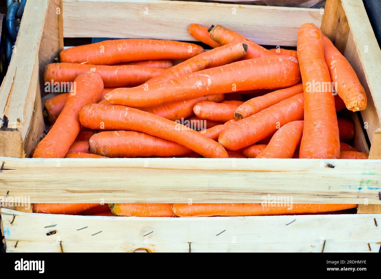 Fresh carrots in wooden box for sale at farmers market. Stock Photo