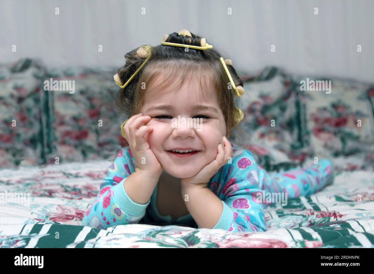 Toddler is ready for bed including pajamas and sponge hair rollers. She