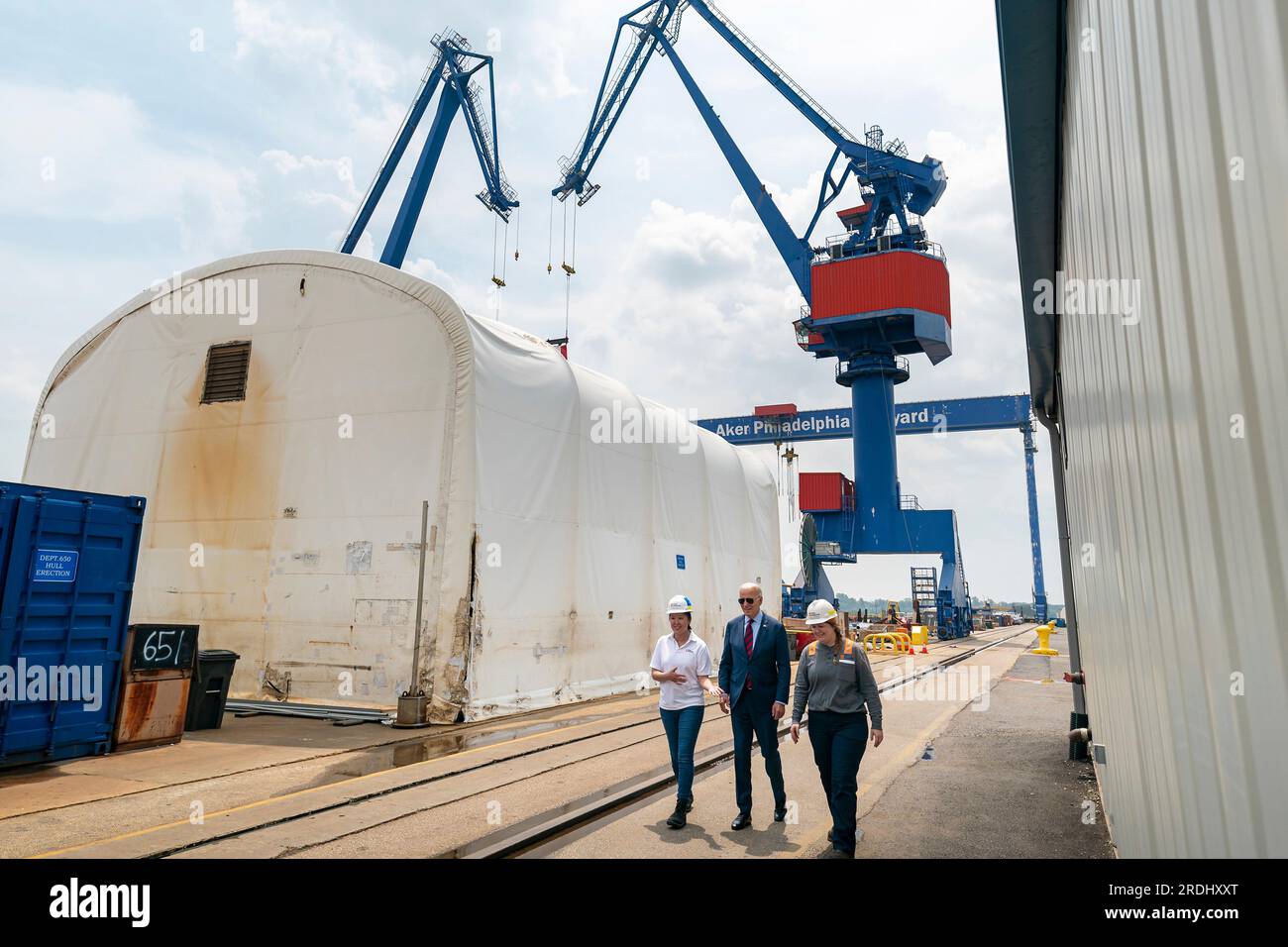 South Philadelphia, United States of America. 20 July, 2023. U.S President Joe Biden, center, is escorted by Emily Andrewson, apprentice welder, right, and Megan Heileman, Manager, PSI Apprentice Program, left, during a visit to the Philly Shipyard, July 20, 2023 in South Philadelphia, Pennsylvania, USA. Credit: Adam Schultz/White House Photo/Alamy Live News Stock Photo