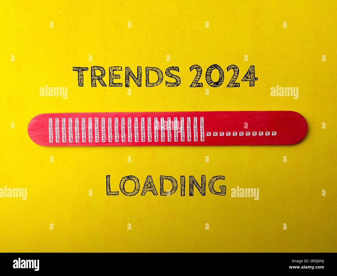 Red wooden stick with the word TRENDS 2024 LOADING on a yellow