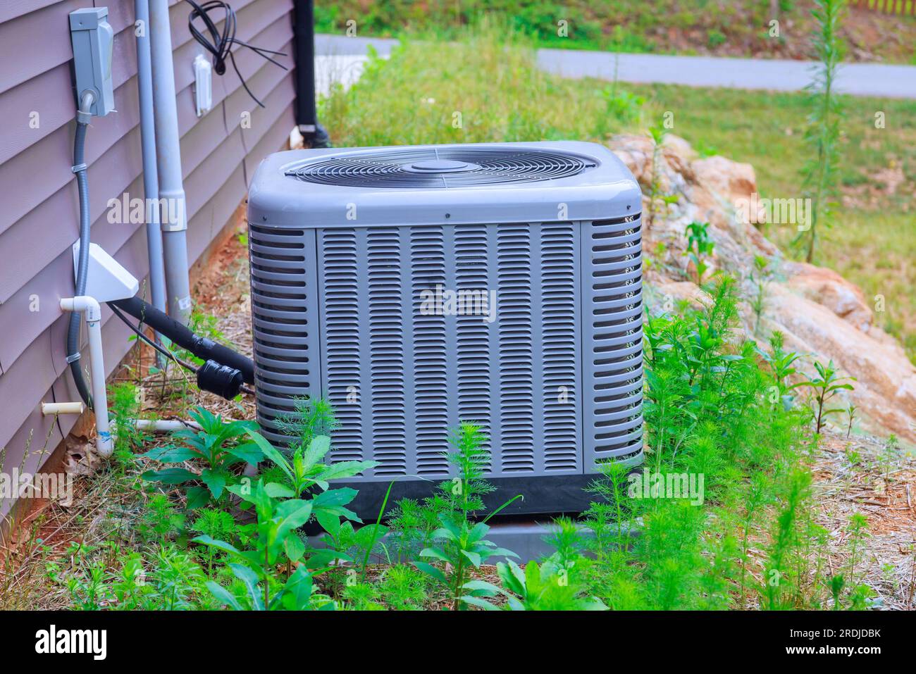 There is an air conditioning unit installed on near house as part of outside air conditioning