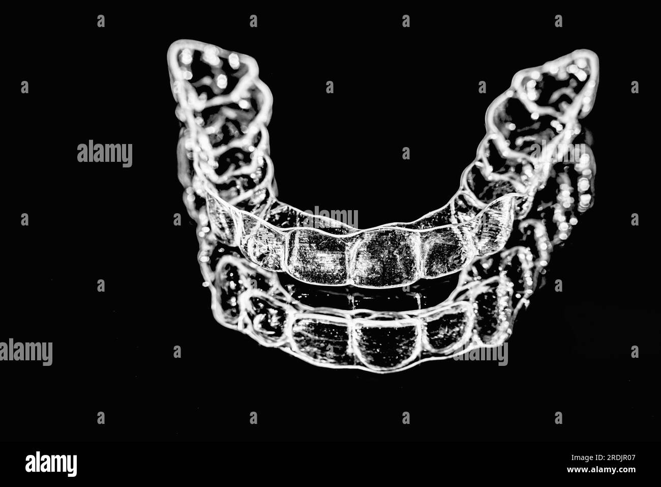 Invisible aligner teeth retainers lie on the mirror in orthodontic