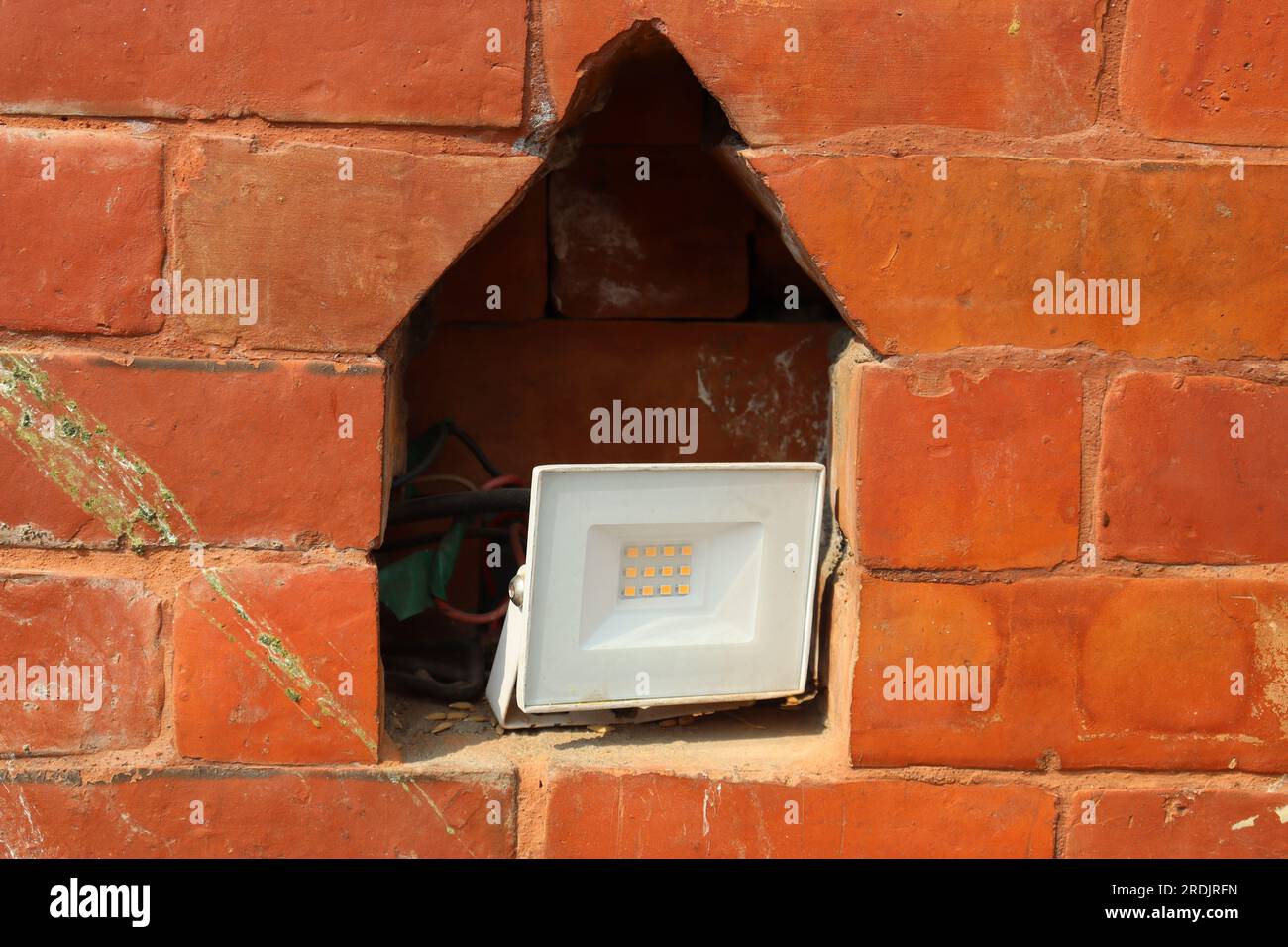 Foot light or spot light kept inside niche of a brick wall to give a classic look , foot light for gardens. Stock Photo