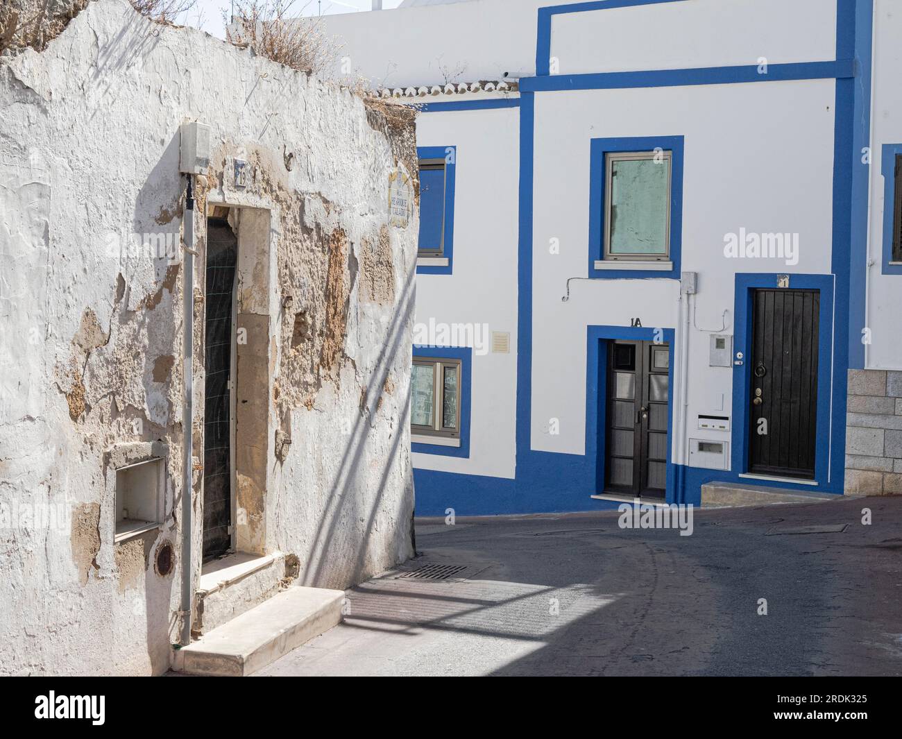 Delapidated houses next to modern houses Rua Henrique Caldo and Rua do Cemiterio Velho Albufeira old town Portugal Stock Photo