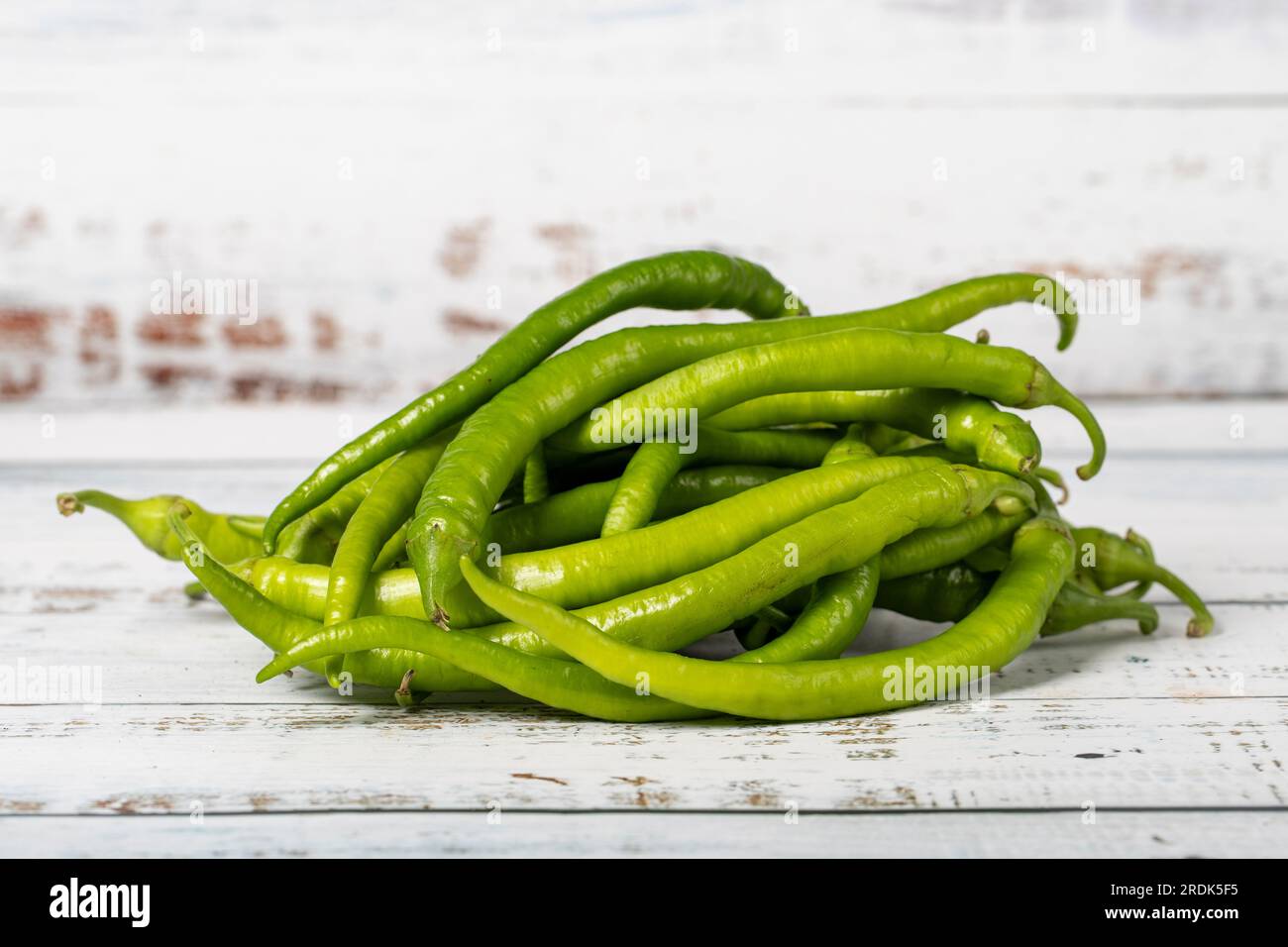 Green pepper on a white wood background. Fresh raw green chili pepper harvest season concept. Vegetables for a healthy diet Stock Photo