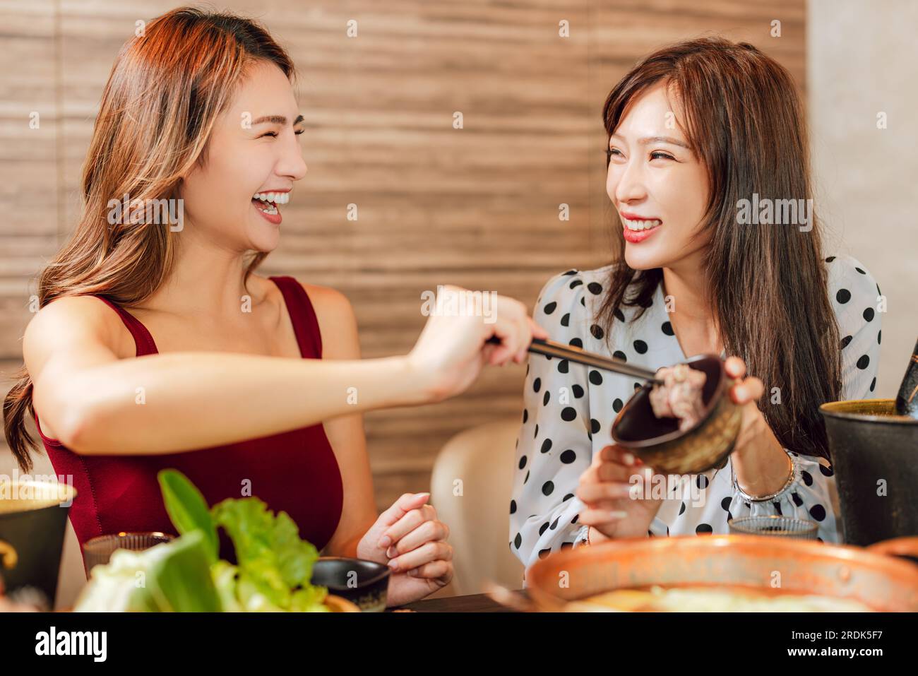 Happy woman dining in hotpots restaurant Stock Photo