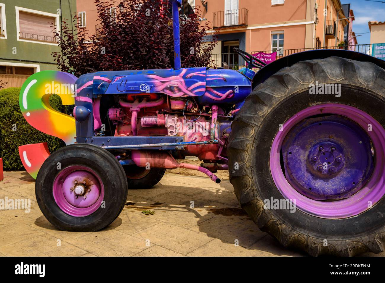 Main square of Penelles with a sign of the name of the town and a painted tractor (La Noguera, Lleida, Catalonia, Spain) ESP: Plaza Mayor de Penelles Stock Photo