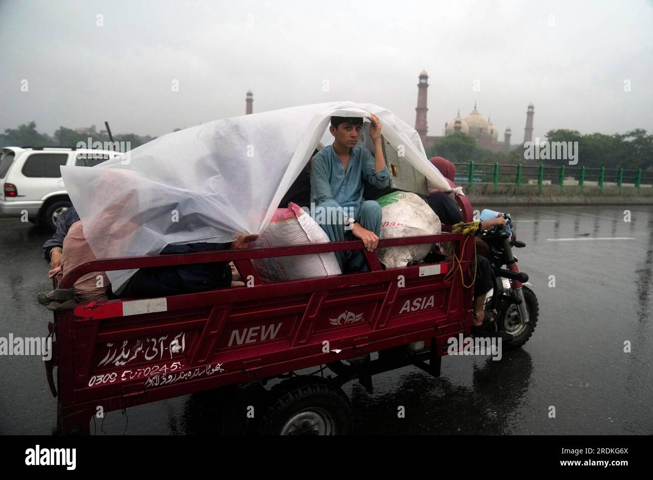 People use plastic sheets to cover themselves traveling during heavy