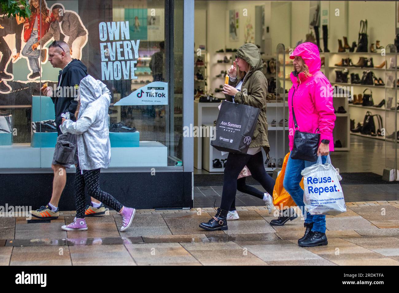 Preston Lancashire.  UK Weather 22 July 2023. Summer sales, shops, and shoppers on a rainy day in the city centre. Forecasters say: 'Rain, heavy at times, through Saturday & Sunday is likely to cause some disruption, particularly to outdoor events. Credit: MediaWorldImages/AlamyLiveNews Stock Photo