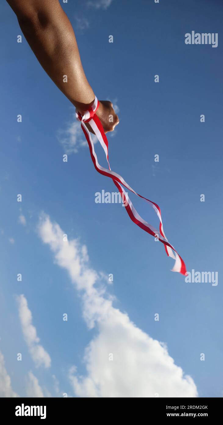 Hand with red and white ribbon, Indonesian independence day celebration concept Stock Photo