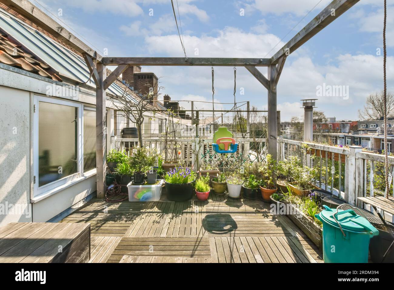 a roof garden with potted plants on the deck and an overhead view of the city in the background, new york, ny Stock Photo