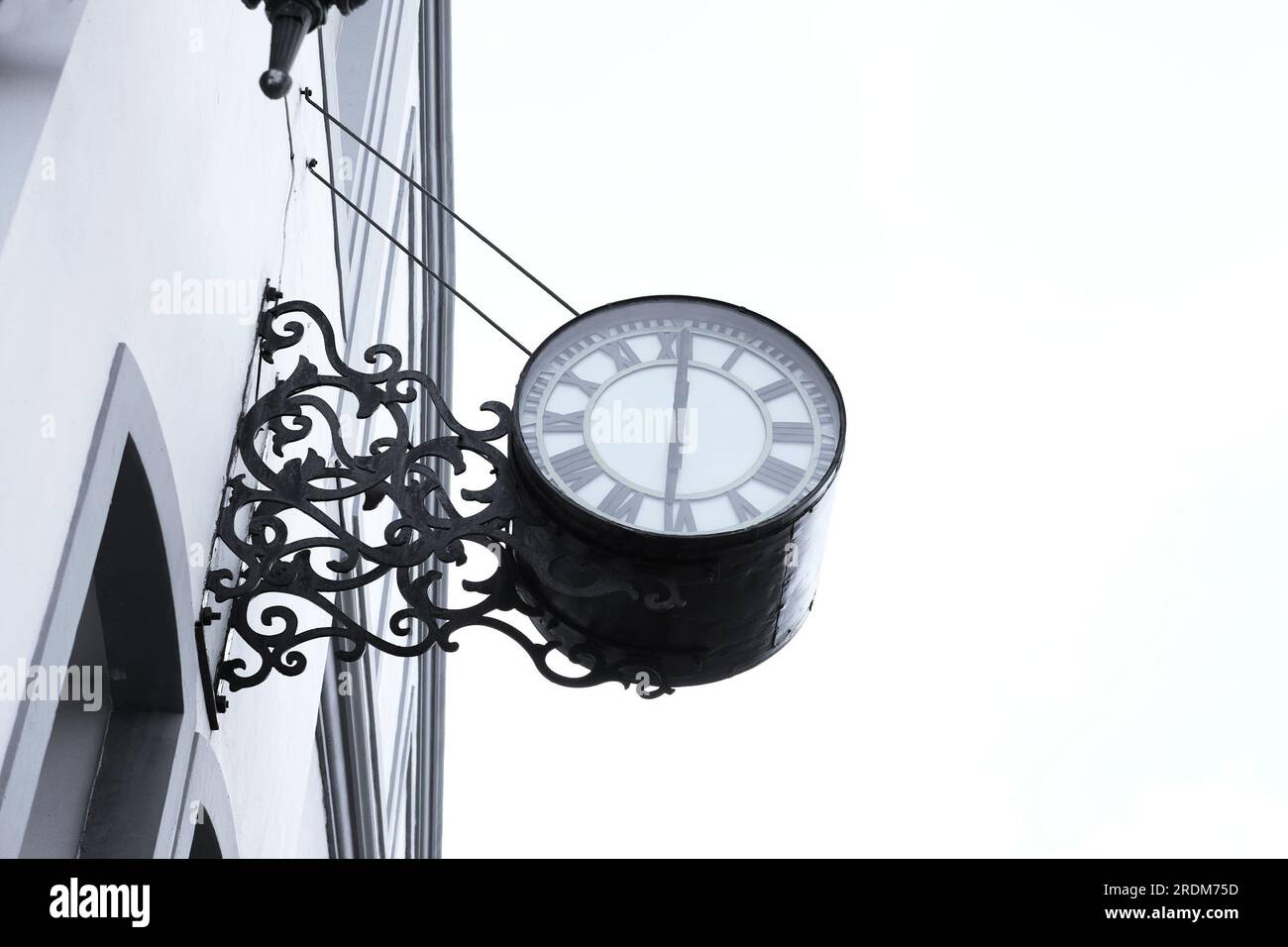 Big round vintage clock on an industrial building, at half past noon