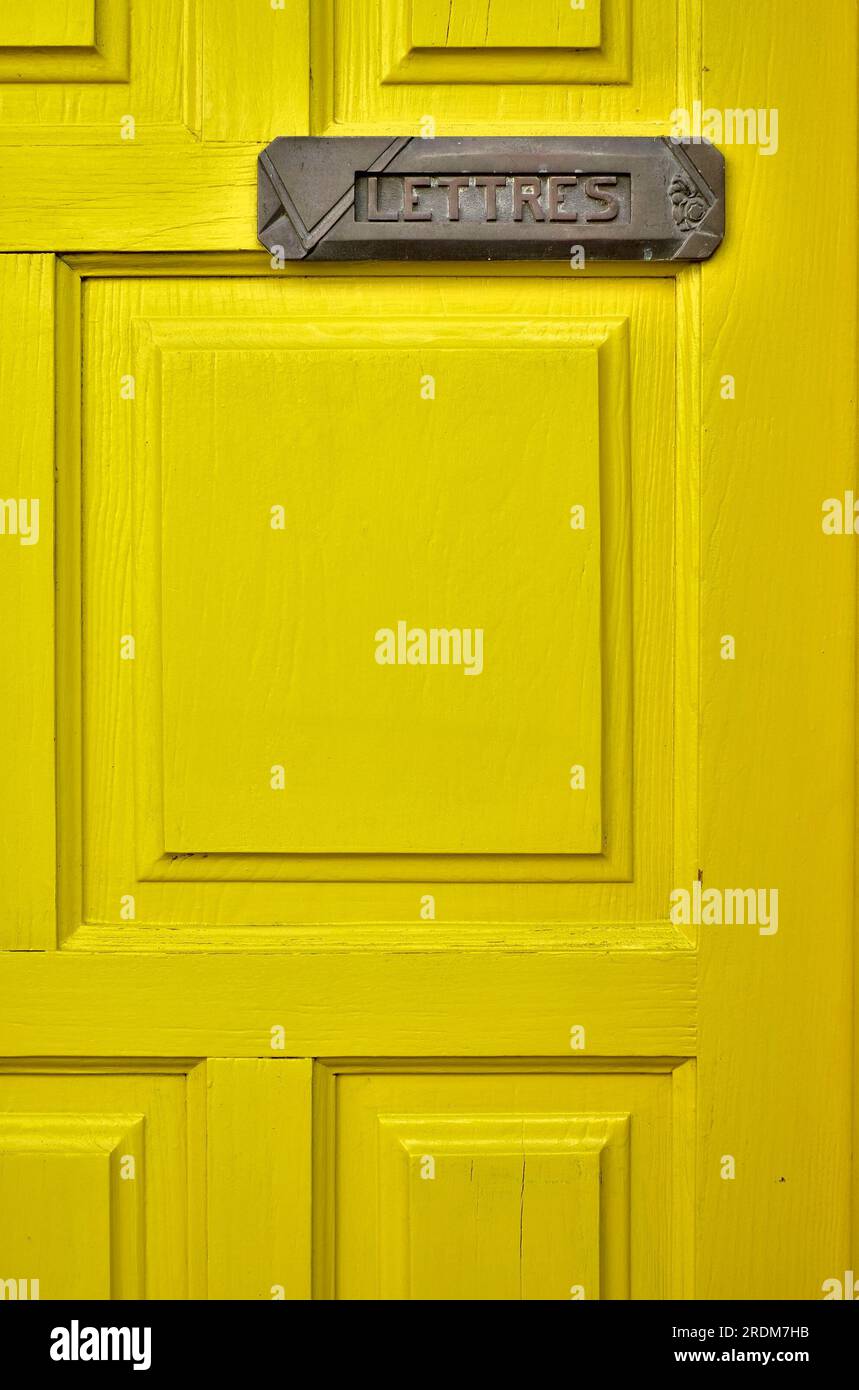 Lemon yellow door with a letter box and a French word LETTRES (English