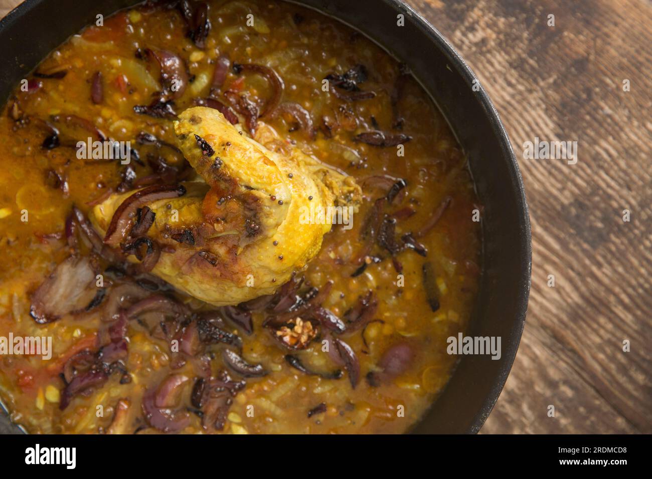 A chicken fillet and wing on the bone that have been homecooked and curried with brown lentils to make a chicken dal. England UK GB Stock Photo