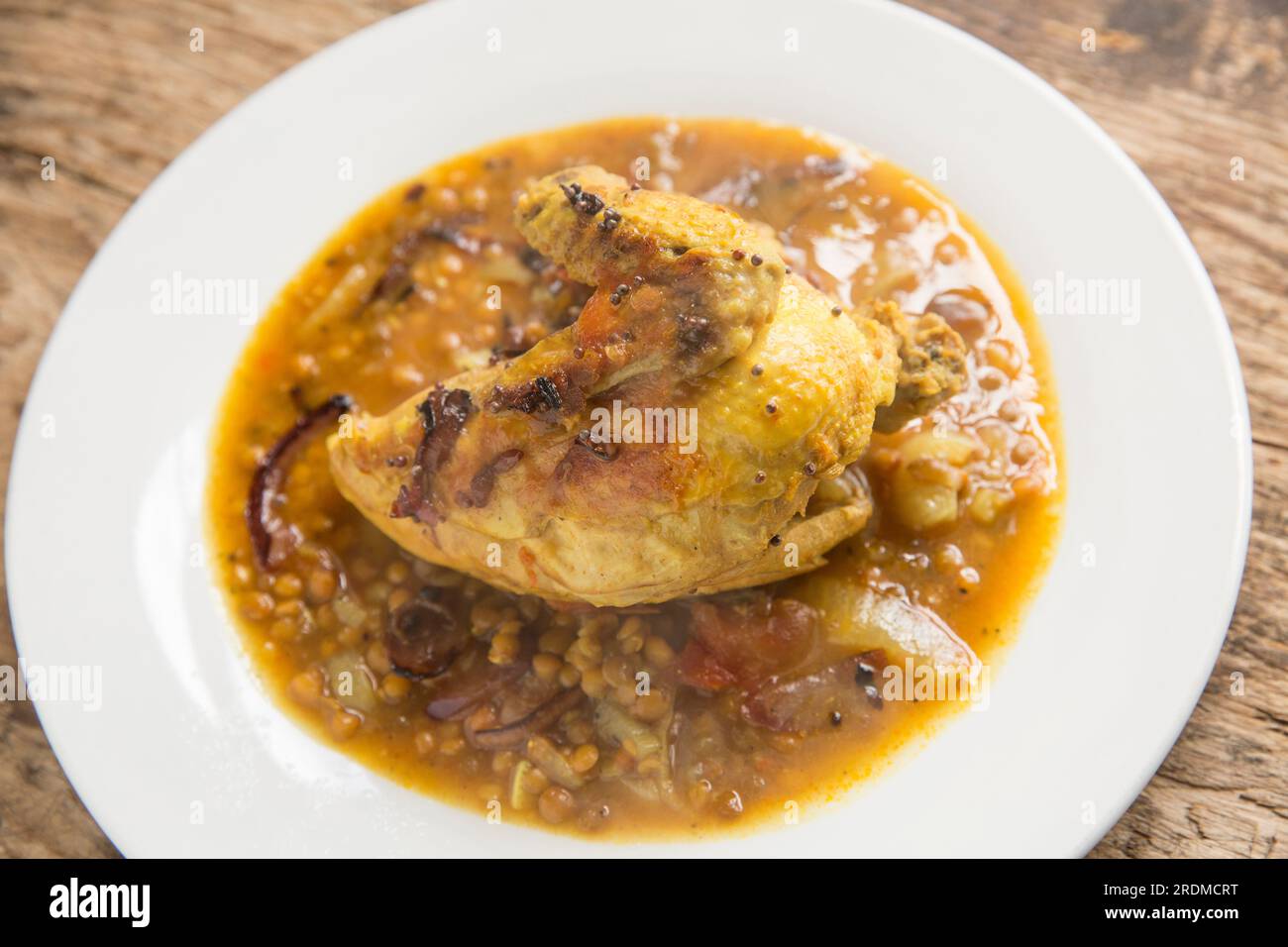 A chicken fillet and wing on the bone that have been homecooked and curried with brown lentils to make a chicken dal. England UK GB Stock Photo