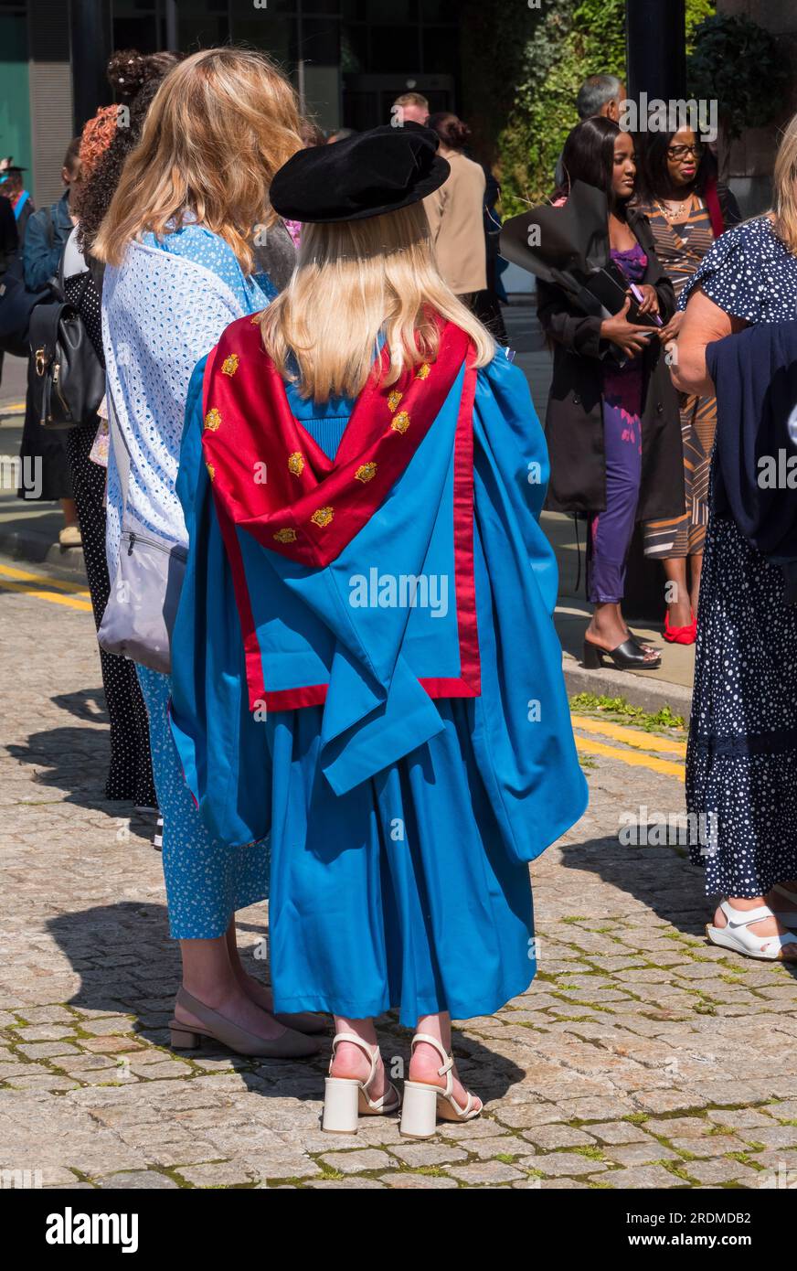 The image is of groups of graduates with family and friends celebrating their achievement as graduates at Manchester Met University Stock Photo