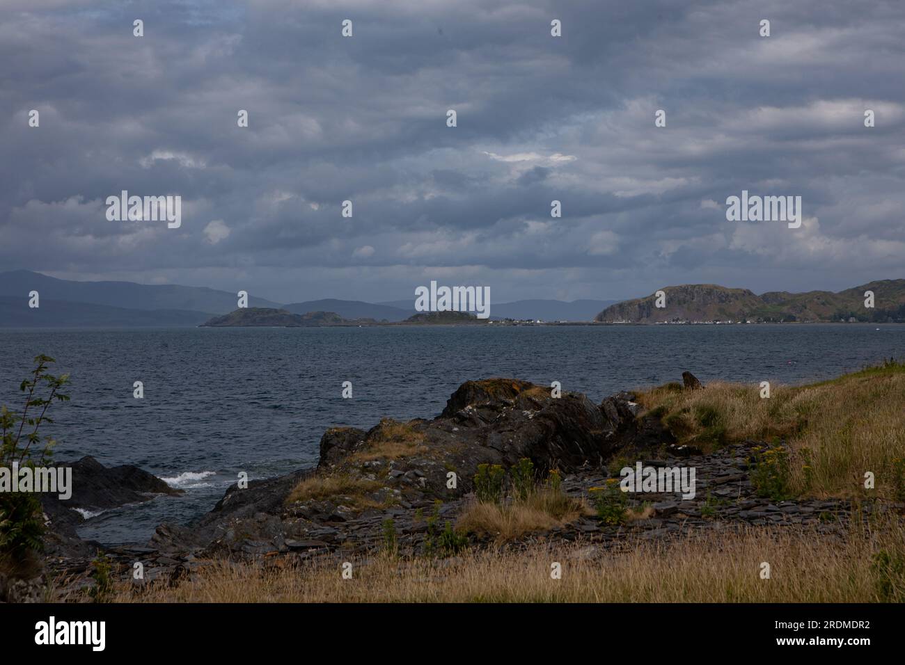 Easdale and Easdale Island in the distance from Luing Island with Mull in the far distance Stock Photo