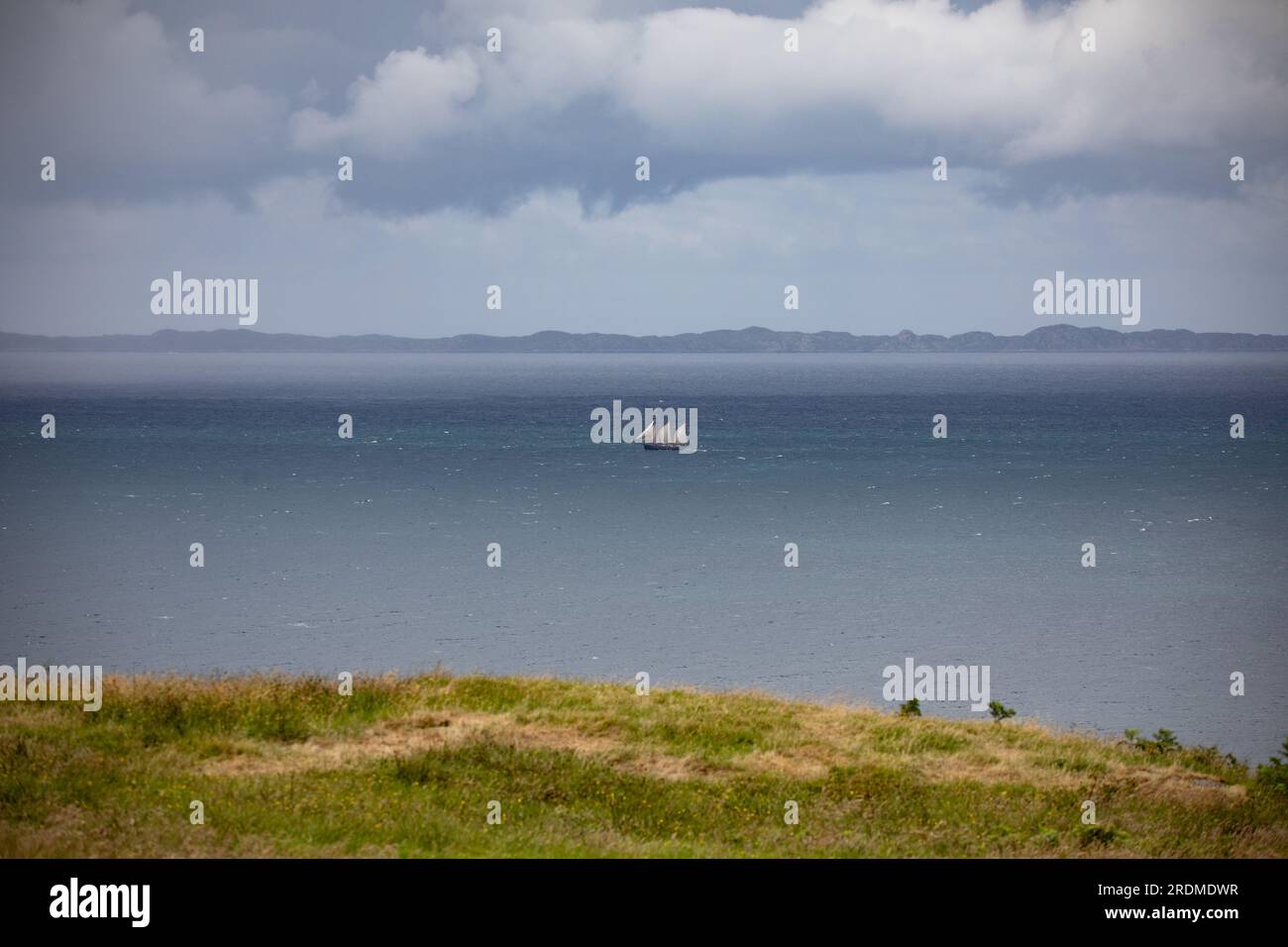 Distant three masted sailing ship between Mull and the Isle of Coll, Inner Hebrides, Scotland Stock Photo