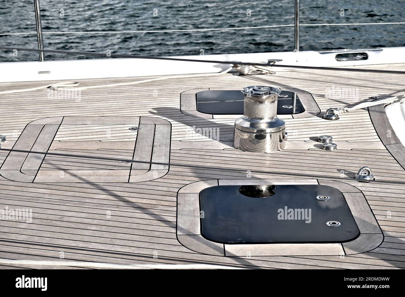 Teak deck, a powerfull winch and deck hatches of a big luxurious yacht