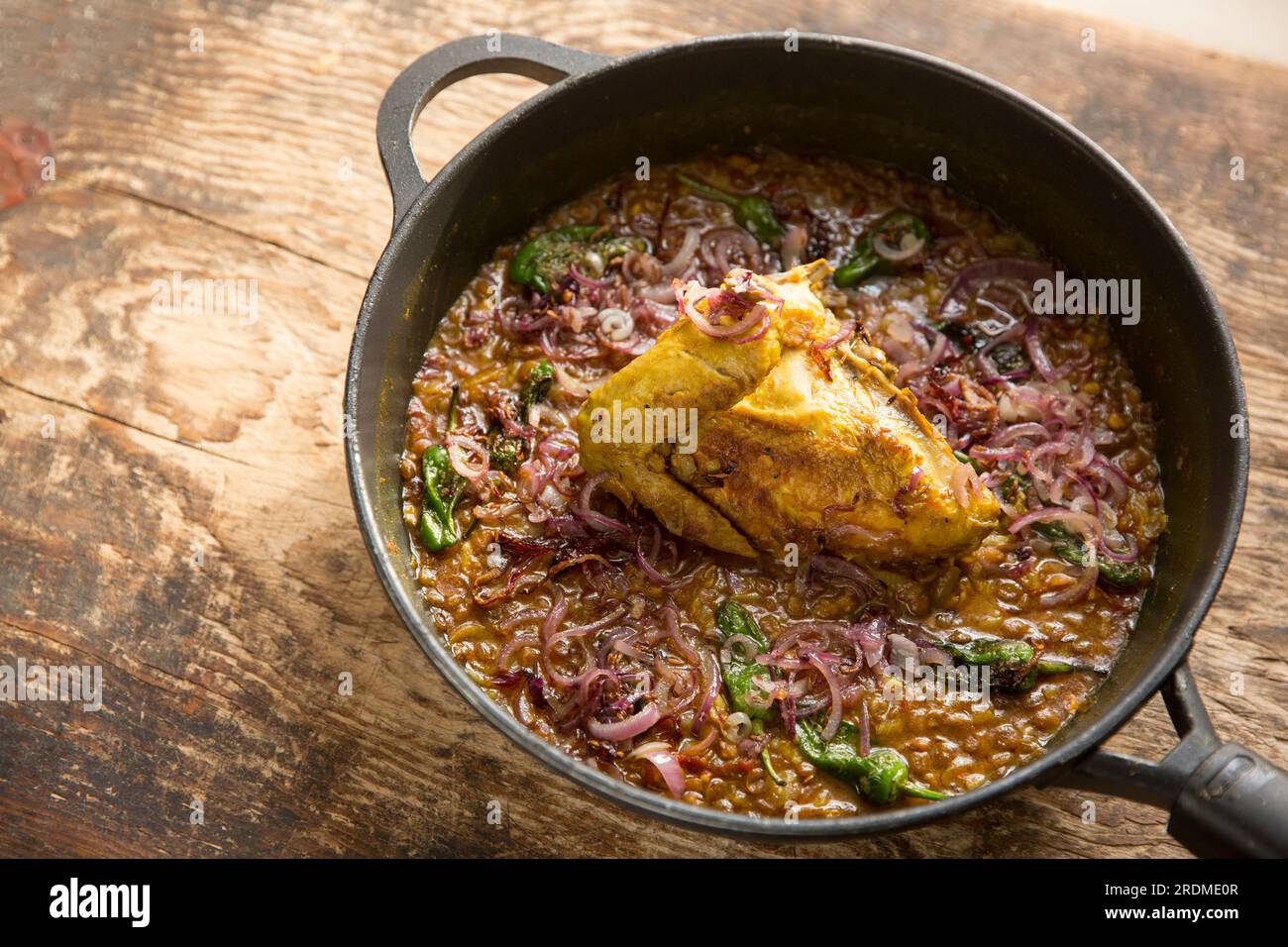 A chicken fillet and wing on the bone that have been homecooked and curried with brown lentils to make a chicken dal. England UK GB Stock Photo