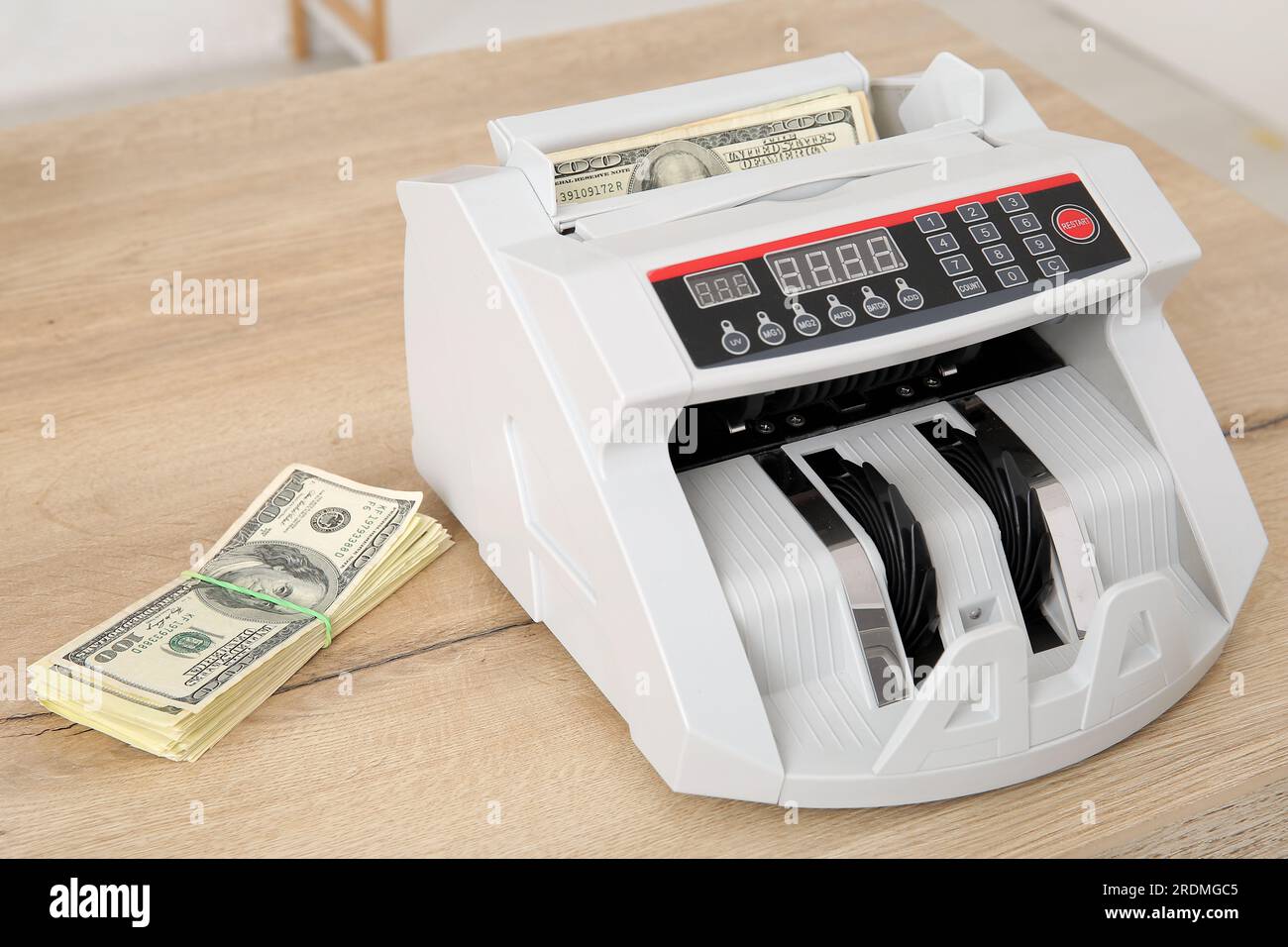 Cash counting machine with dollar banknotes on table in office, closeup ...