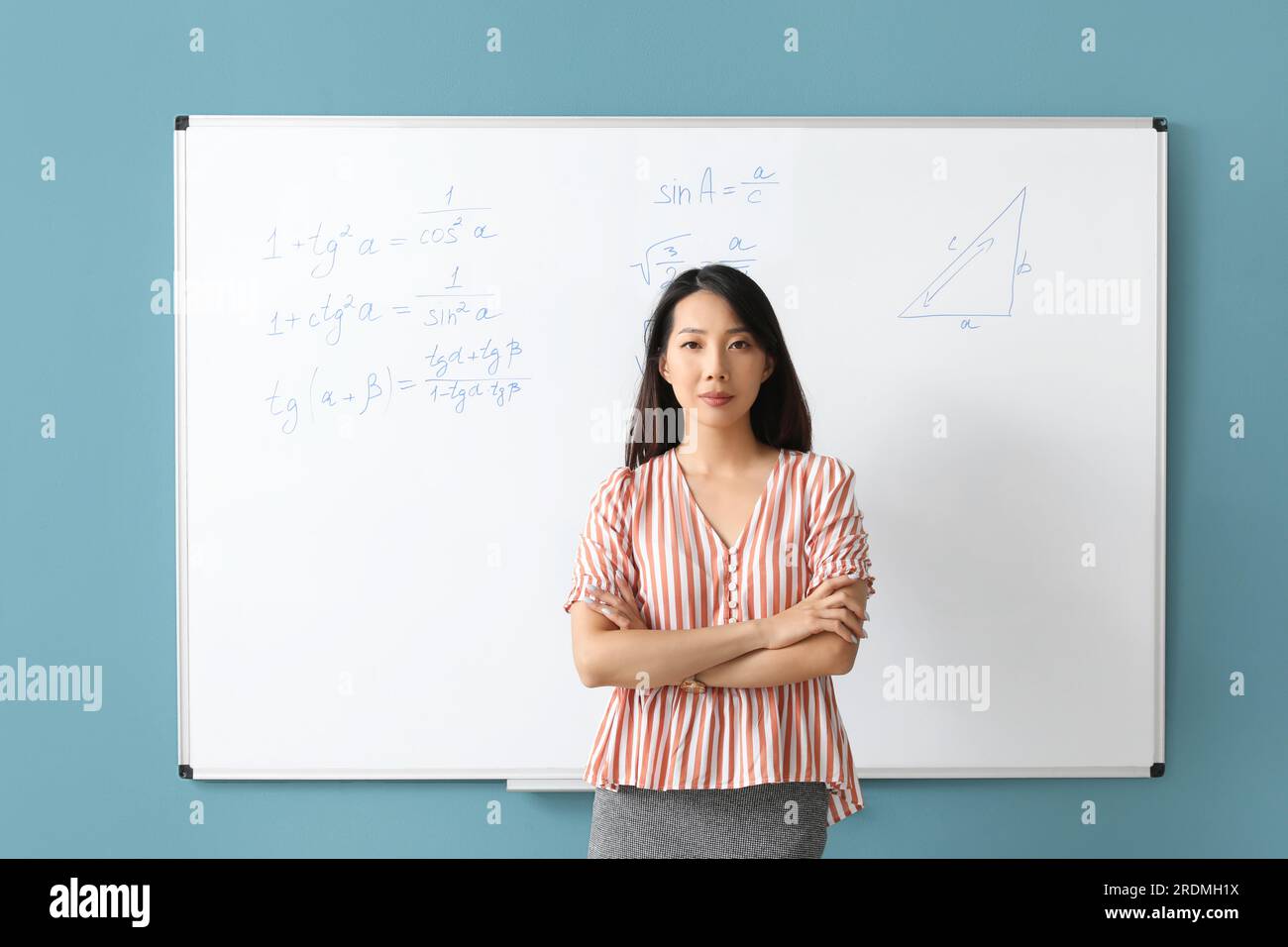 Asian Math teacher near flipboard in classroom Stock Photo Alamy