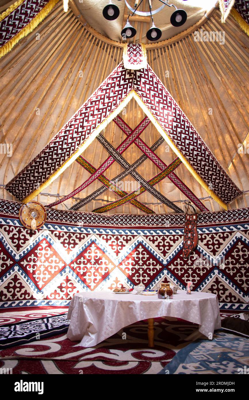 the interior of the national traditional Kazakh festive yurt with patterns and a table. Stock Photo