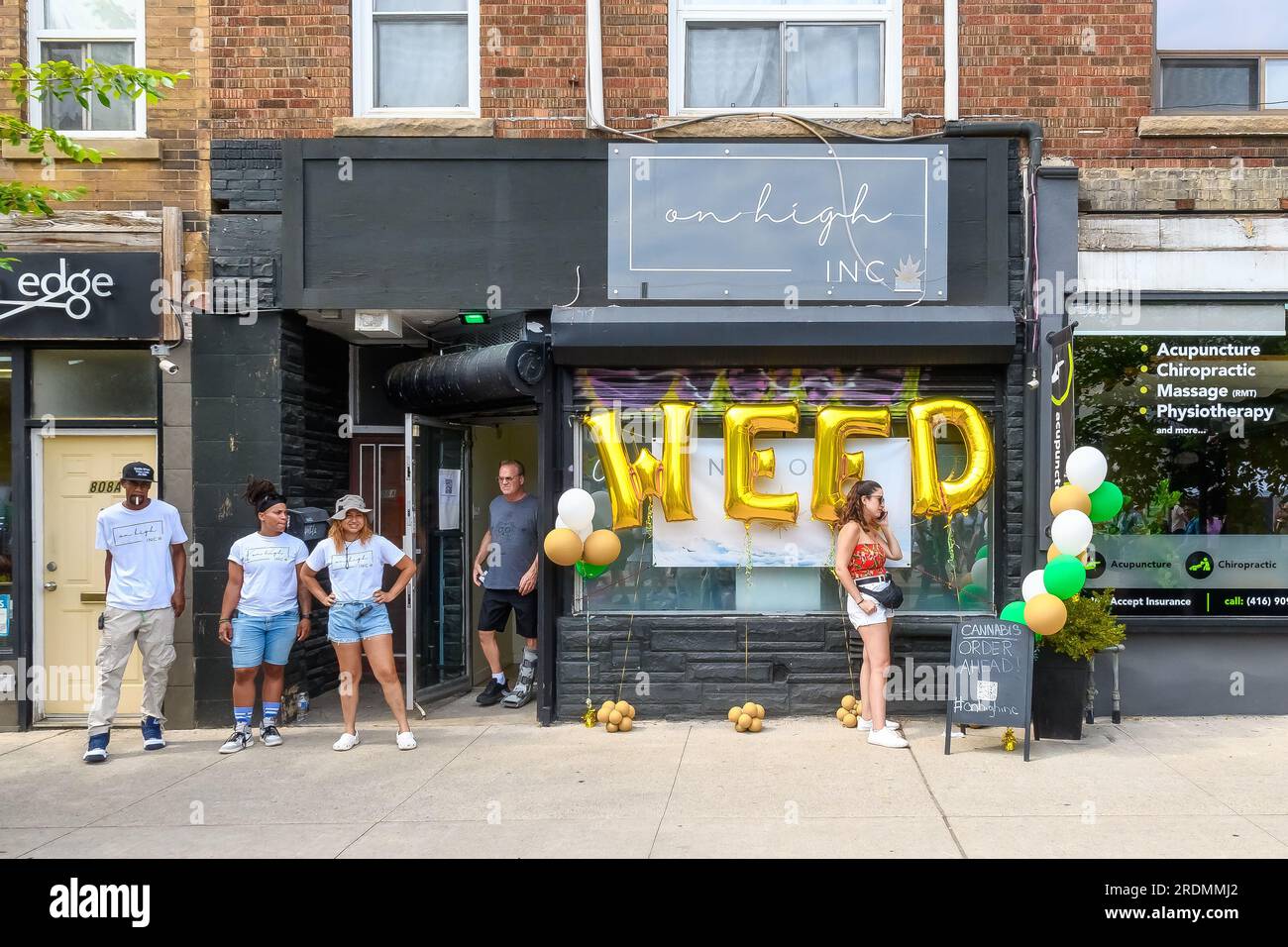 Toronto, Canada - July 19, 2023: A group of employees standing in front of a cannabis or weed store. The drug is legal in the country. Stock Photo