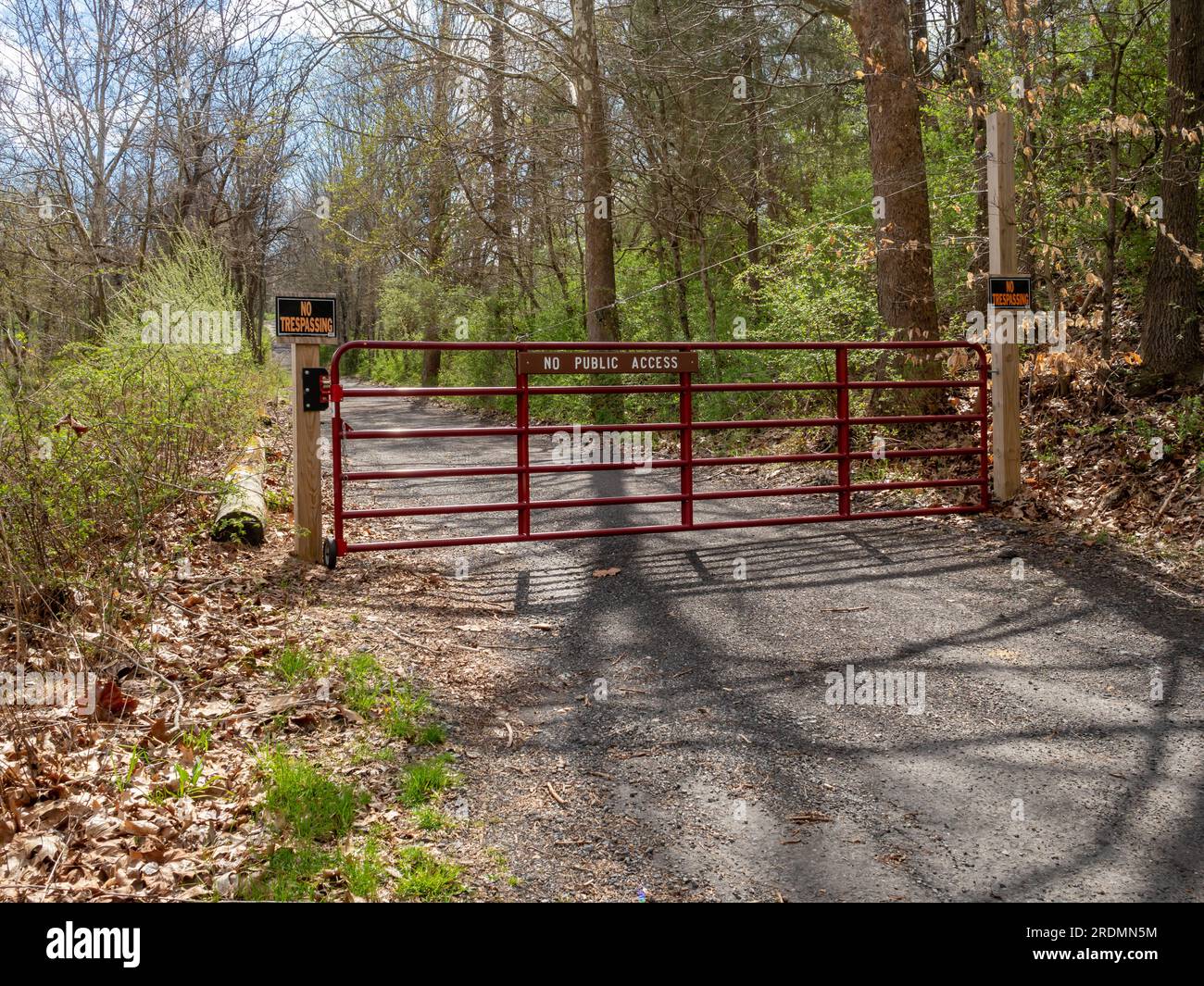 fence and signs 'no public access' and 'no trespassing' on private road in USA Stock Photo