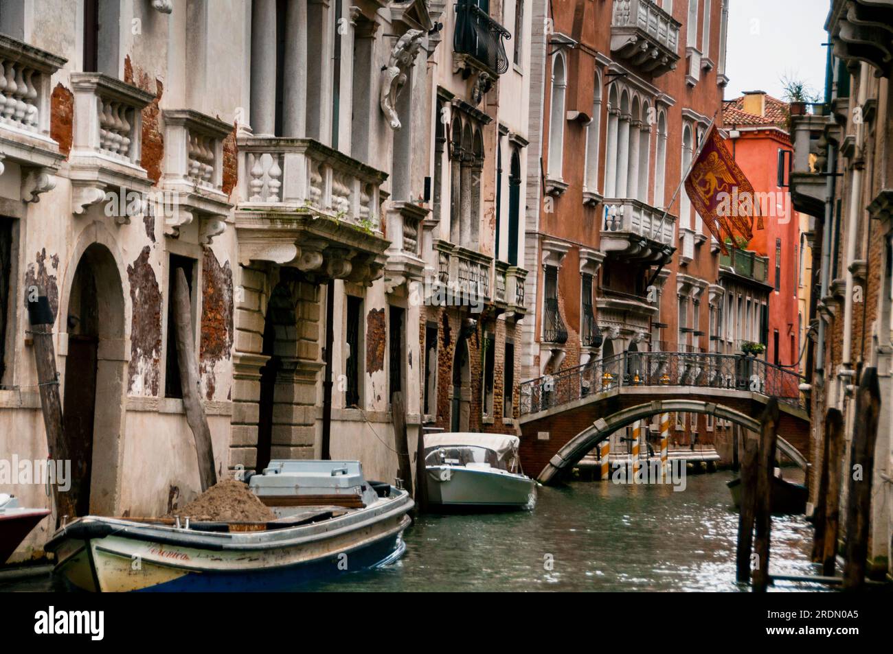 Venetian canal portal, flag and footbridge in Venice, Italy Stock Photo