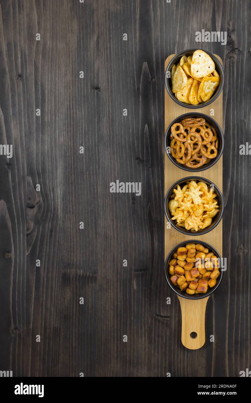 Withtop Snacks Lager beer and snacks on stone table. Nuts, chips, pretzel. Top view ...