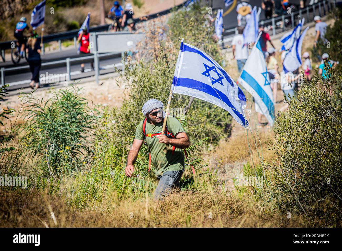 Abu Gosh, Israel. 22nd July, 2023. A protester holds the Israeli flag near the town of Abu Gosh. Protesters joined a mass march to the Knesset in Jerusalem as part of a last-ditch effort as the coalition readies to pass into law a bill that would curtail judicial oversight over its decisions. Credit: SOPA Images Limited/Alamy Live News Stock Photo