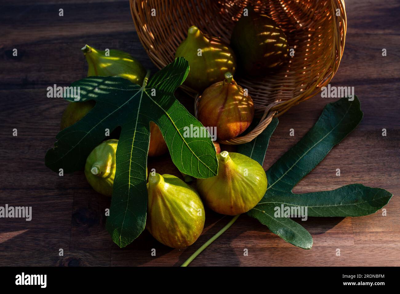 A few yellow figs on an brown wooden background in sunshine. Stock Photo