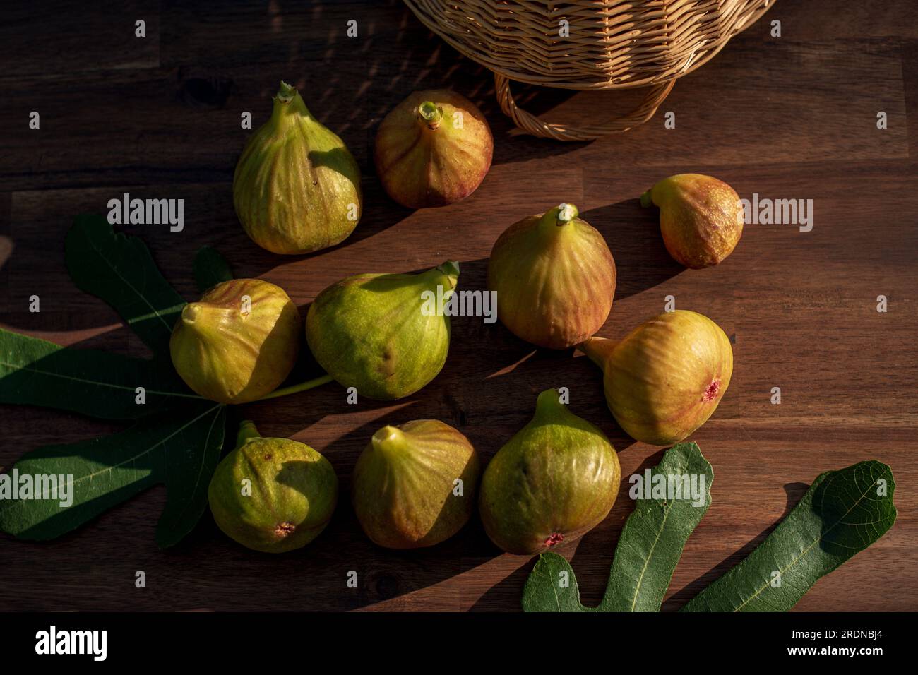 A few yellow figs on an brown wooden background. Stock Photo