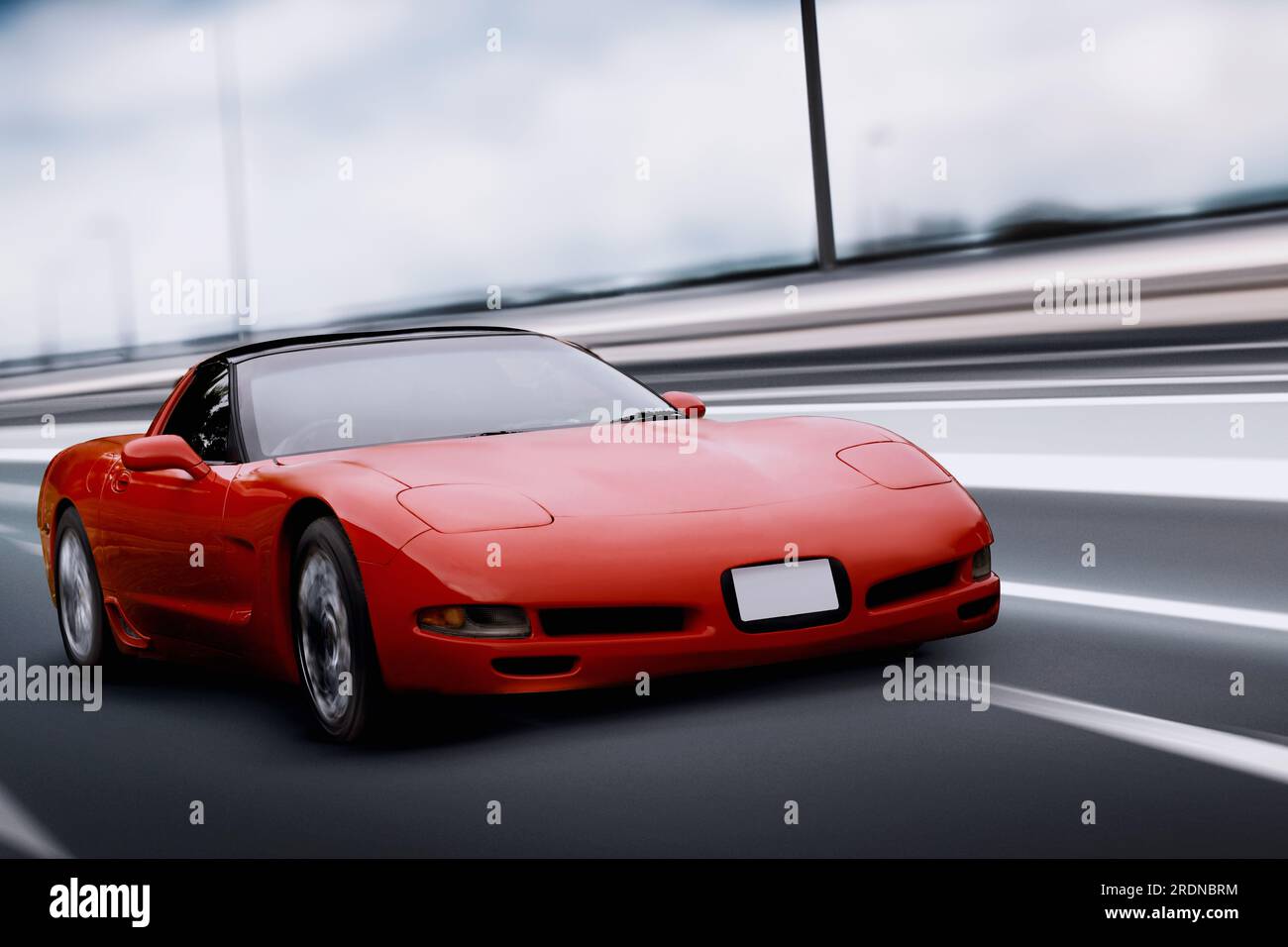 Izmir, Turkey - June 3, 2023: An image capturing the dynamic speed of a red 2000 Chevrolet Corvette racing down the highway. Stock Photo