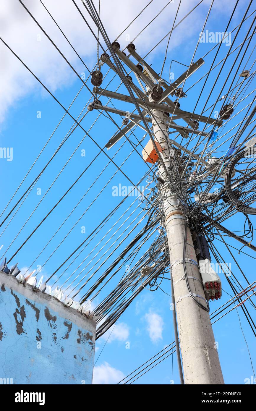 Utility pole with many wires against the blue sky. Stock Photo