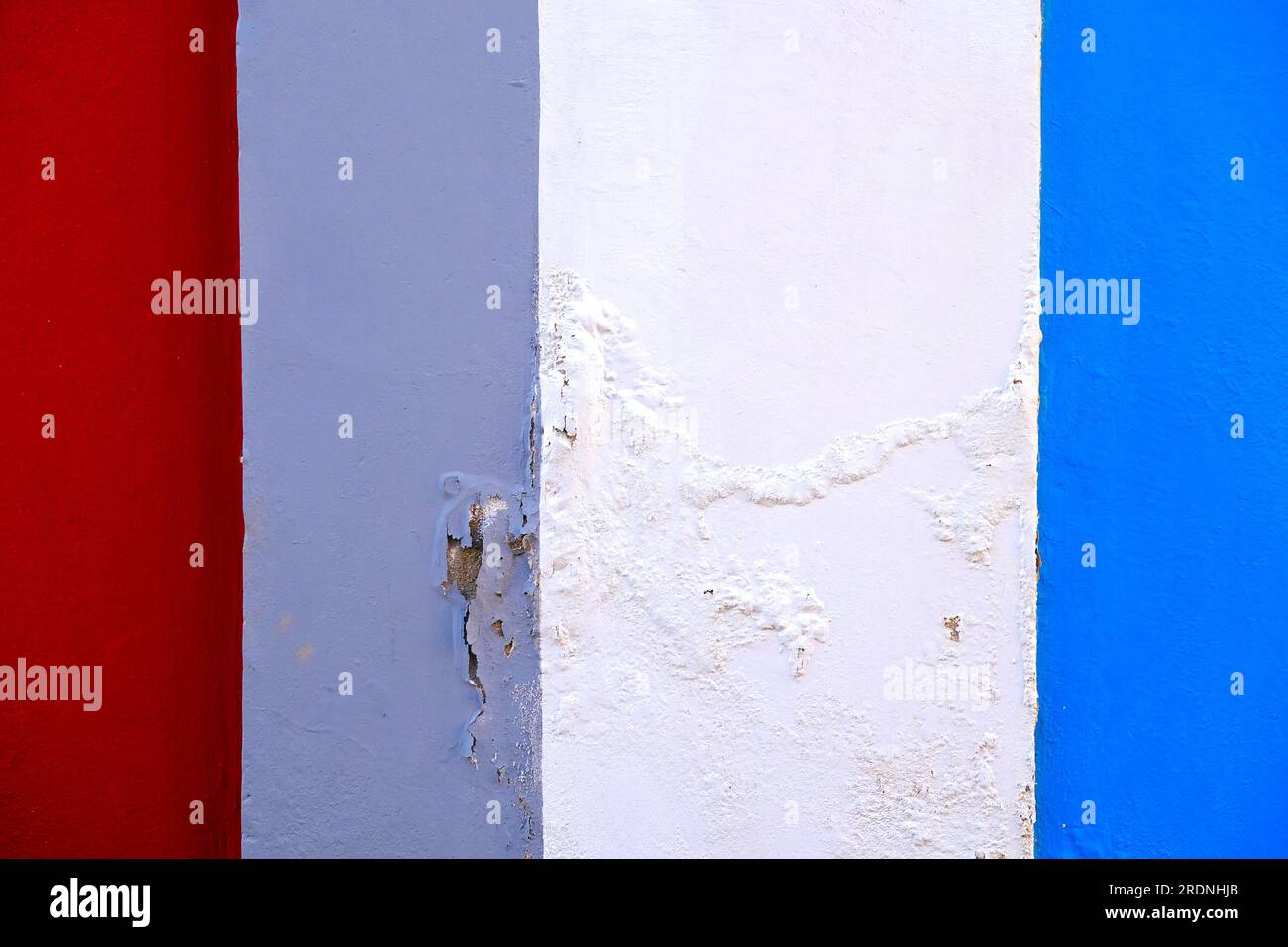 Abstract wall section with flaking paint and colorful painted bands ...