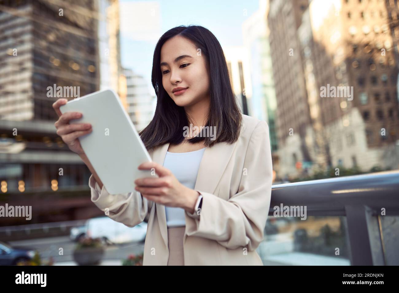 Young Asian business woman professional standing in city using tablet. Stock Photo