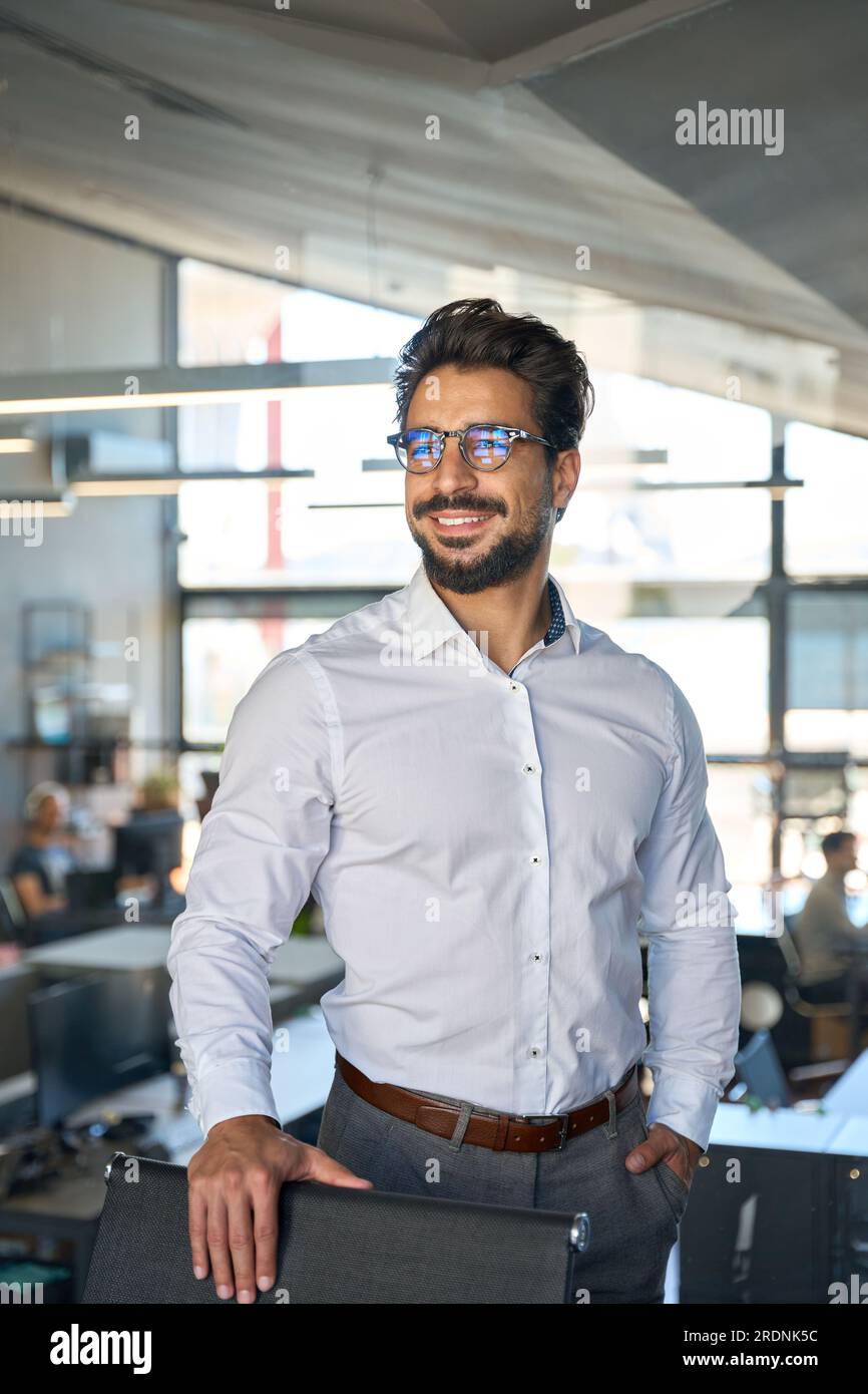 Confident Latin young business man wearing eyeglasses looking away. Stock Photo