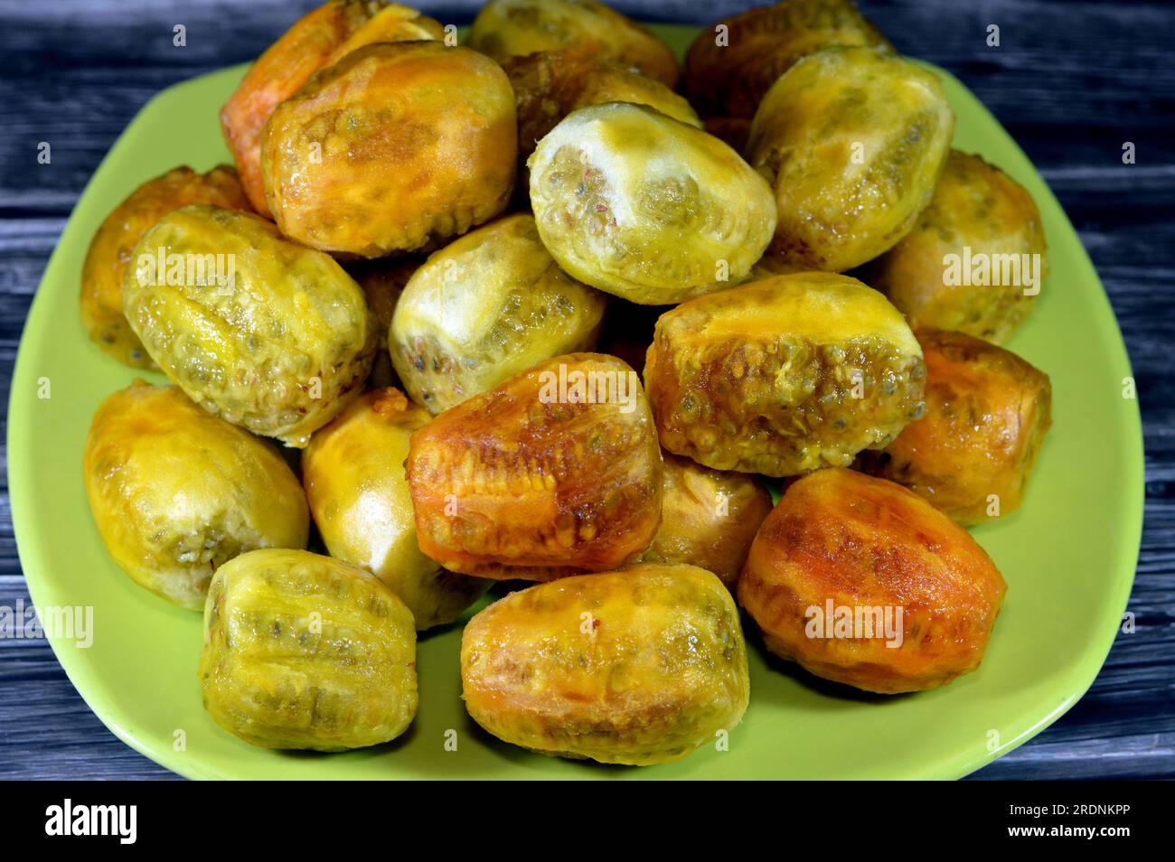 A pile of peeled fresh prickly pear fruit in a plate isolated on wooden
